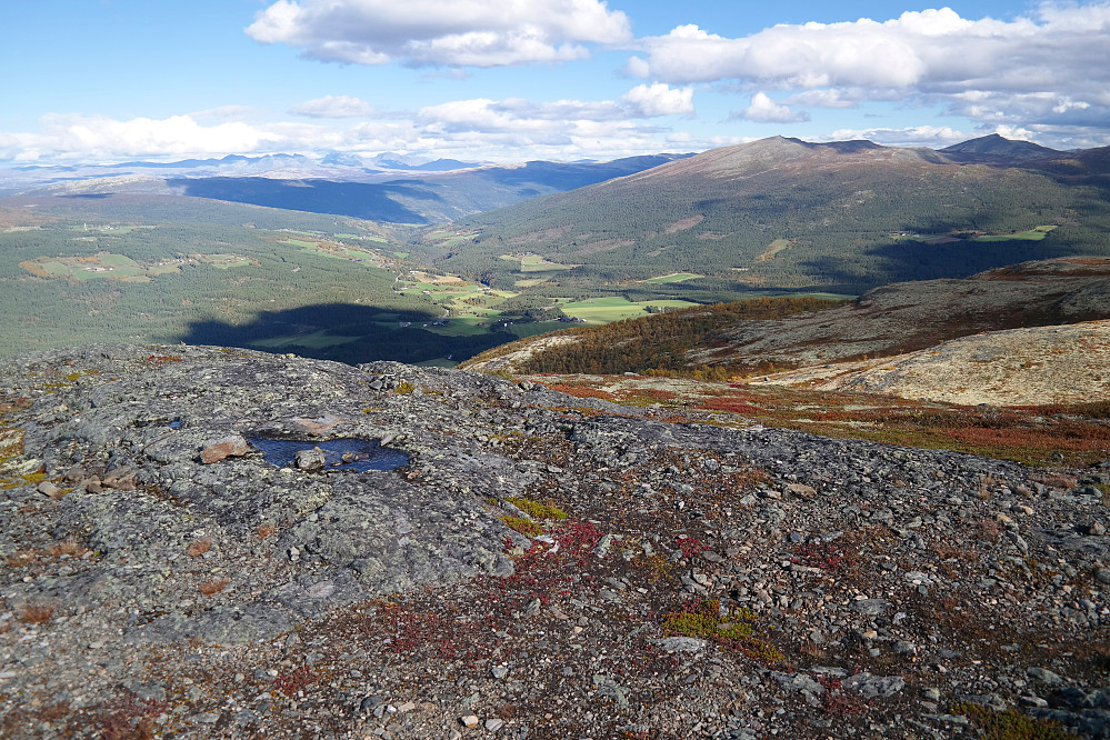 Utsikt mot nordøst fra Ørnkampen (1162). Nede i dalen ligger Skogbygda, og lenger bak Heidal. Langt bak til venstre ses Rondane.