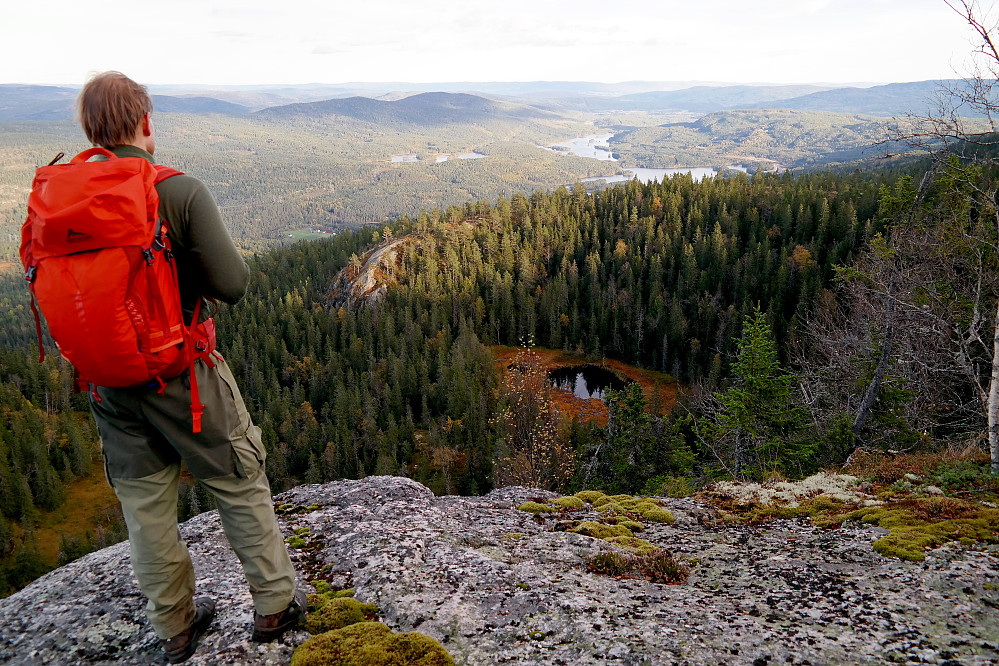 Øyvind står utpå en avsats få meter øst for toppen av Dugurdsnatten (770). Utsikt mot sørøst. De to største innsjøene nede i dalen til høyre er Breidvatnet og Langevatnet.