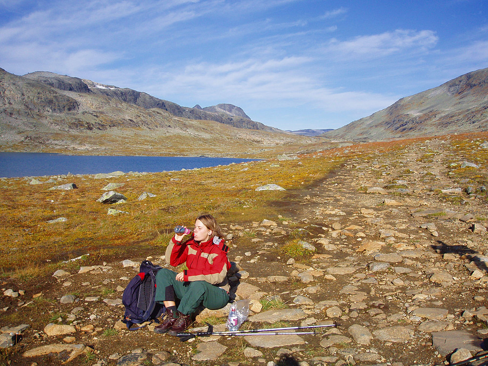 Pause på stien like øst for Nedre Høgvagltjønnet. Vi er akkurat i krysset hvor stiene fra Gjendebu og Olavsbu møtes. Skyggen fra skiltet ses helt til høyre i bildet.