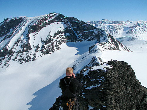 Erik fotograferer fra Nørdre Bukkeholstinden Ø1 (2090). Like nedenfor til høyre er Nørdre Bukkeholstinden Ø2 (2085). Det store fjellet til venstre er Styggehøe (2213).