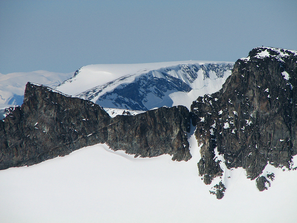Storgrovtinden (2229) til venstre, Bakarste Storgrovhøe (2259) helt til høyre. Imellom disse og lengre bak, ses det langt flatere fjellet Loftet (2170), hvor den hvite toppvarden er synlig.