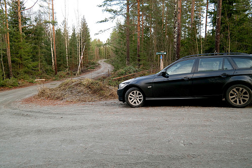 Parkering i Ellingsby-krysset. Veien mot Vardehøgda (335) går innover i bildet. Bommen ses på venstre side av veien. Skiltet "Flyktningeruta" er bak bilen.