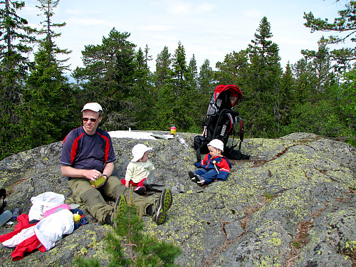 På Snaukollen, også kalt Knivfjellet (661 moh), vest i Finnemarka. Frida og Erling med datter slapper av.