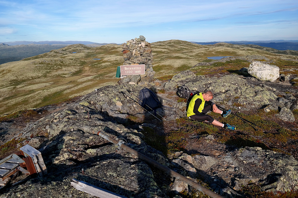 På toppen av Hestnatten (1200), eller Heisnatten som det står på skiltet på toppvarden. I bakgrunnen, til høyre for varden, er Taklinatten (1202).