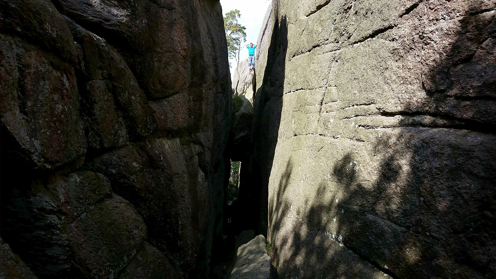 Morten står oppå steinen som er kilt fast i kløfta.