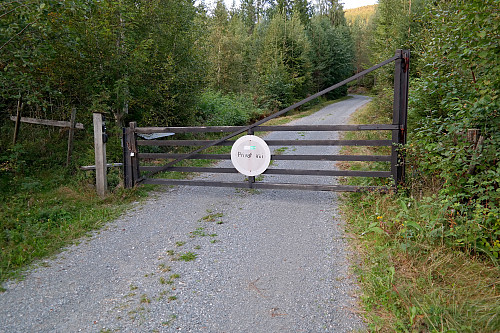 Låst bom på Solskinnveien. Grind med lavere trågjerde på begge sider, så kommer man med sykkel her, må den løftes over. 