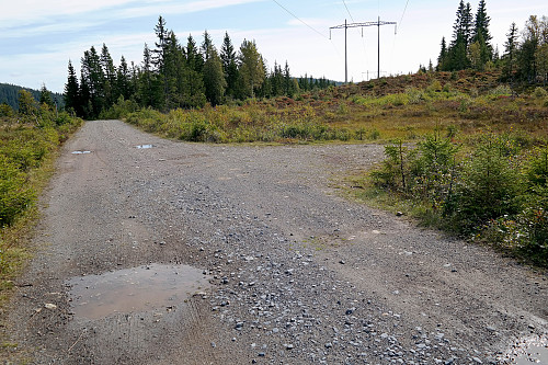 Parkeringslomme under høyspentlinja. Stien til Dalasjøhøgda (627) starter litt lengre bak, på venstre side av veien. En stolpe med noen skilt er så vidt synlig der stien begynner.