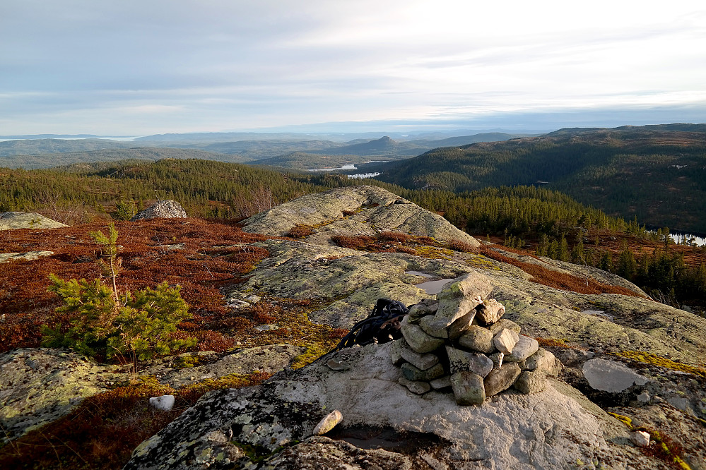 Toppvarden på Den Runde Kollen (874) er helt i forgrunnen. Bildet tatt mot sør/sørøst. Den markerte toppen i bakgrunnen nokså midt i bildet, er Tekslehogget (721).