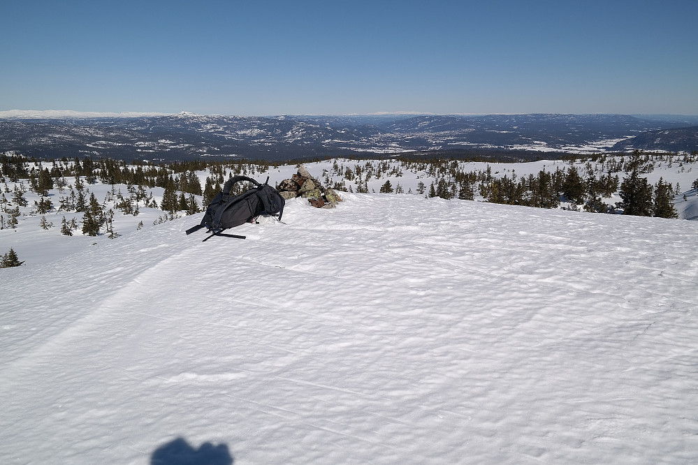 Sekken min ved toppvarden på Evjuseterfjellet trig.punkt (758). Nedi dalsøkket i bakgrunnen, litt til høyre for varden, ses Kongsberg.