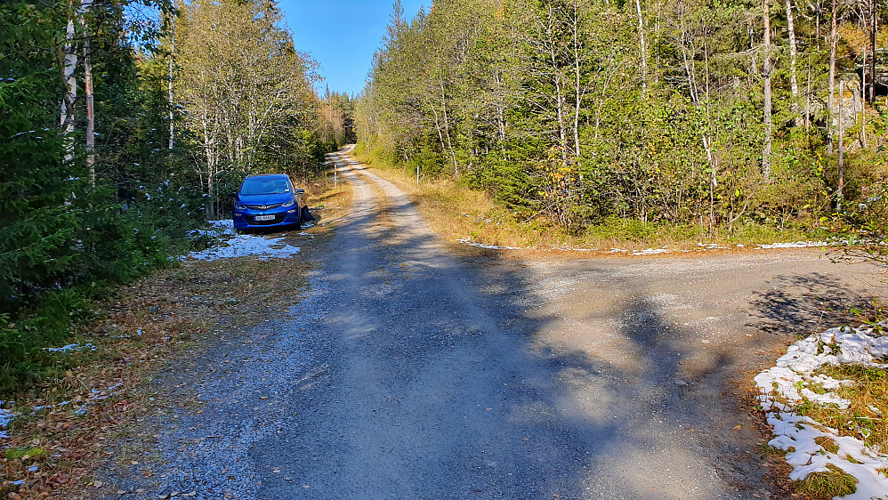 Parkering ved siden av veien i dette krysset. Til  høyre går veien opp mot gården Setre. Rett frem er veien mot Noreåstjønn, og der ses den nå åpne bommen.