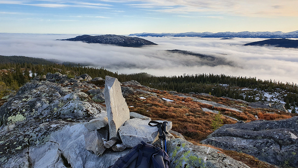 Helt i forgrunnen er toppvarden på Gvamsnuten (985). Utsikt sørover. Toppen som stikker godt over tåkehavet litt til venstre i bildet, er Bodik (965).