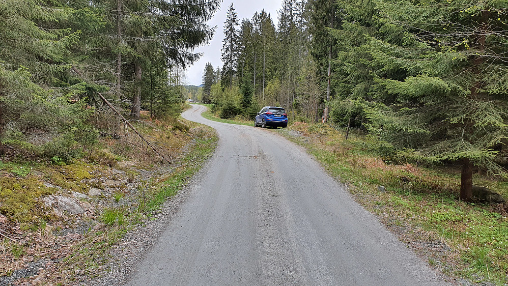 Parkering langs grusveien Nedre Dalsroen. Gården Fallet kan skimtes bakerst der veien forsvinner.