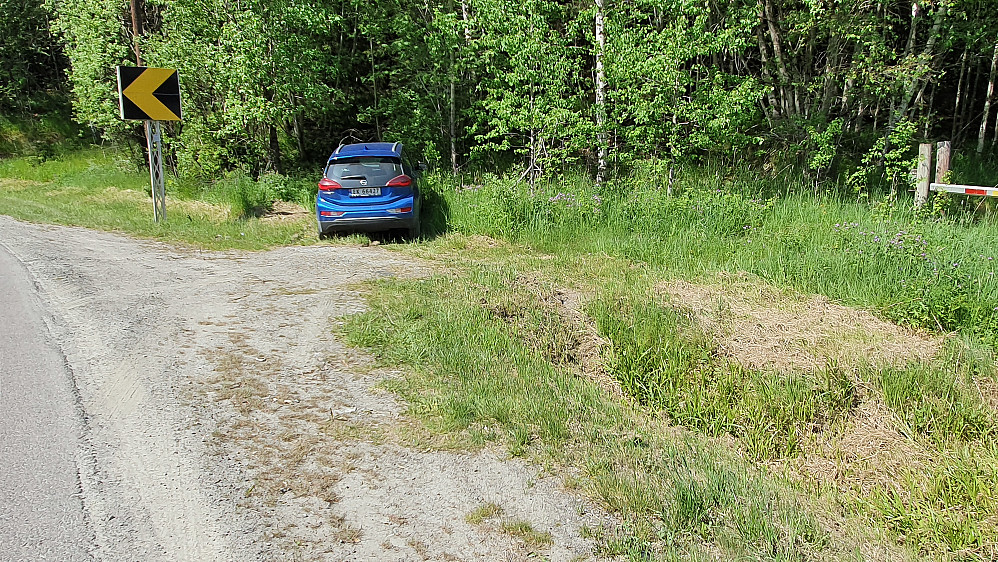Ser ut som jeg har parkert i grøfta, men det er en liten lomme der med plass til en bil. Til høyre ses litt av den låste bommen hvor traktorveien går.