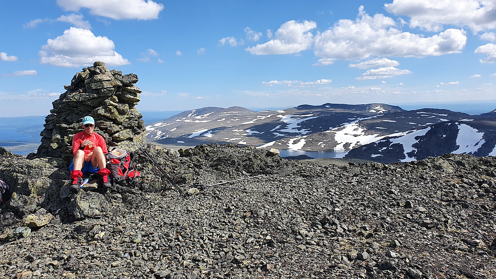 Erling foran toppvarden på Veslebotnskarvet (1778). Fjellet i bakgrunnen og nærmest til høyre for toppvarden, er Skogshorn (1728).