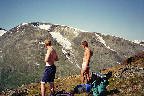 20.08.1995 - Hans Petter og Johan Kristian tar en pust i bakken. Vi er kommet et stykke opp mot høyde 1945 og Dumhøe-platået. Nydelig utsikt mot Loftet (2170) i bakgrunnen. For et vær, for en dag!