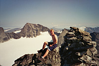 20.08.1995 - Hans Petter ved toppvarden på Skardstinden (2373 moh). Bak ses en topp som nok er en god del mer kjent og en av få topper i landet som er høyere enn der vi sitter: Galdhøpiggen (2469).