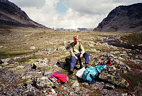 06.07.1996 - Jeg slapper av i Øvre Russglopet. Vi ser nordøstover, med Gloptinden (1678) oppe til høyre. Langt bak ses Nautgardstinden (2258) dekket av et godt lag med nysnø.