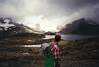 28.07.1996 - Nils Brede skuer utover Store Mjølkedalsvatnet. I bakgrunnen lyser Mjølkedalsbreen opp i det grå skydekket.