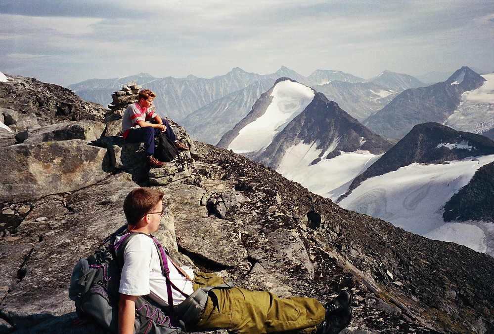 19.08.1996 - Vi nyter utsikt og varmende sol fra høyde 2084, nesten 300 meter sørvest for Midtre Tverrbottinden Sør (2106). Godt fornøyde etter en fin ryggtravers i deilig vær ble vi sittende slik en stund og se ned på Leirvassbu og sørover i Jotunheimen.