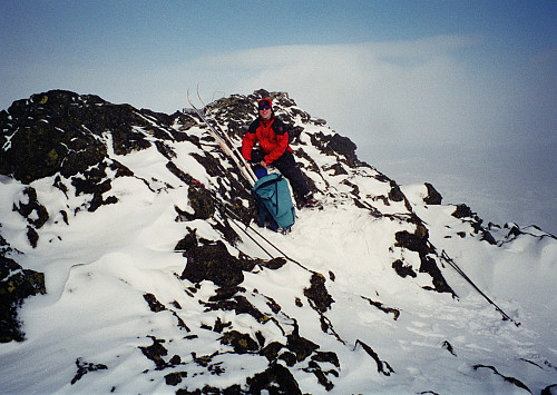 19.04.1997 - Hans Petter i kaldt og surt vær på toppen av Hindnubban (1879). Det blåste kuling fra nordvest, dvs fra venstre. Vi har slått oss ned i le for vinden her. 