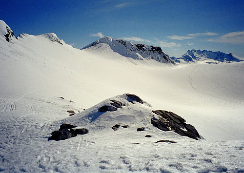 01.06.1997 - Bildet er tatt litt sør/sørvest for Søraustre Smørstabbtinden (2030), mot Søre Smørstabbtinden (2033, i midten). Hurrungane ses lenger bak til høyre. Mine skispor ses i snøflanken til venstre.