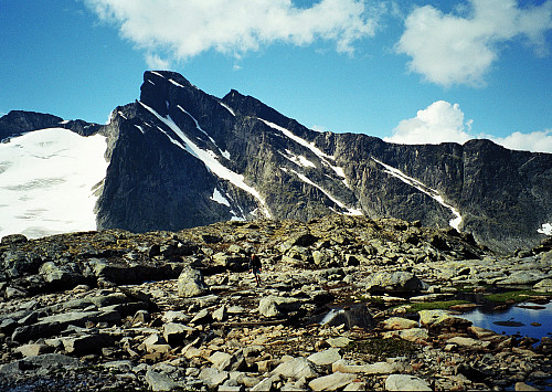13.07.1997 - Gudmund er ved det lille vannet på rundt 1760 meters høyde, 500 m sørvest for Nordre Skarvflytinden (2073). Høyest i bakgrunnen er Nørdre Knutsholstinden (2185).