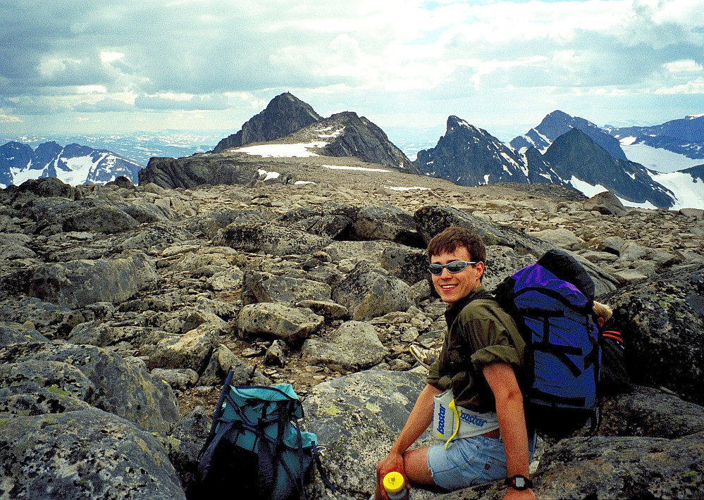 13.07.1997 - Kai Roger på Skarvflyløyfttinden (2250). Vi ser sørvestover den flate og brede ryggen til Austre Leirungstinden (2288), som er høyest og nesten midt i bildet. Den store toppvarden ses godt. 