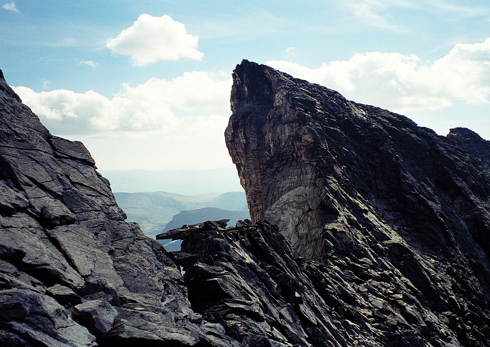 17.08.1997 - Hettpiggen (2261) på Snøhetta, sett fra nord. Et stykke nedenfor toppen, litt til høyre for eggen, ses 2 personer på vei opp, øverst på de solbelyste svaene. Jeg klatret opp via den delvis solbelyste ryggen til høyre for det store skyggefulle området til høyre for de 2 personene.