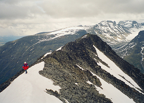 17.07.1998 - Toppryggen på Skagsnebb (2003), sett fra hovedtoppen mot Ø1. Gisle kommer nærmest, Grete er lenger bak og Kai Roger fremdeles på toppen av Ø1. Bak til høyre ses Skardstinden (2373), og Galdhøpiggen (2469) ennå mer til høyre med toppen oppe i skyene.