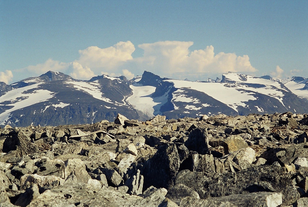 31.07.1999 - Jotunheimen sett fra Midtre Hestbreapiggen (2160). Galdhøpiggen (2469) til venstre, Skardstinden (2373) i midten, og Bukkehøe (2314) til høyre i bildet. Bak Jotunheimen ruver bygeskyene, beliggende over Valdres et eller annet sted.