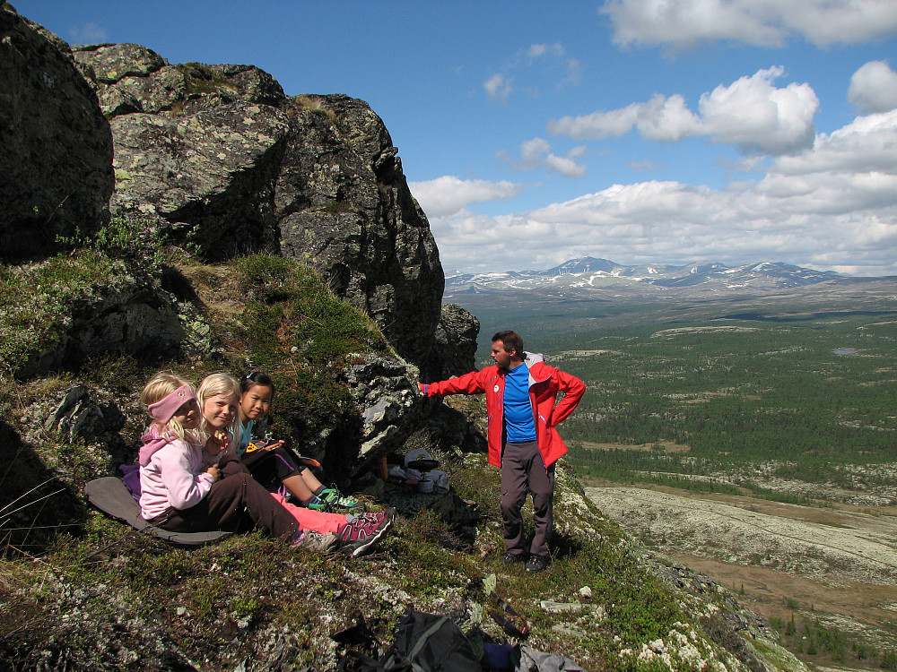 09.06.2014 - Vår glimrende lunsjplass i den bratte nordøstsiden på Svartfjellet (1154). Toppen er like over kanten oppe til venstre. Langt bak ses Rondane.