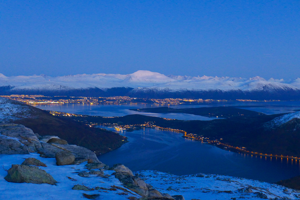 Fint å se snødekte fjell og gatelys i byen