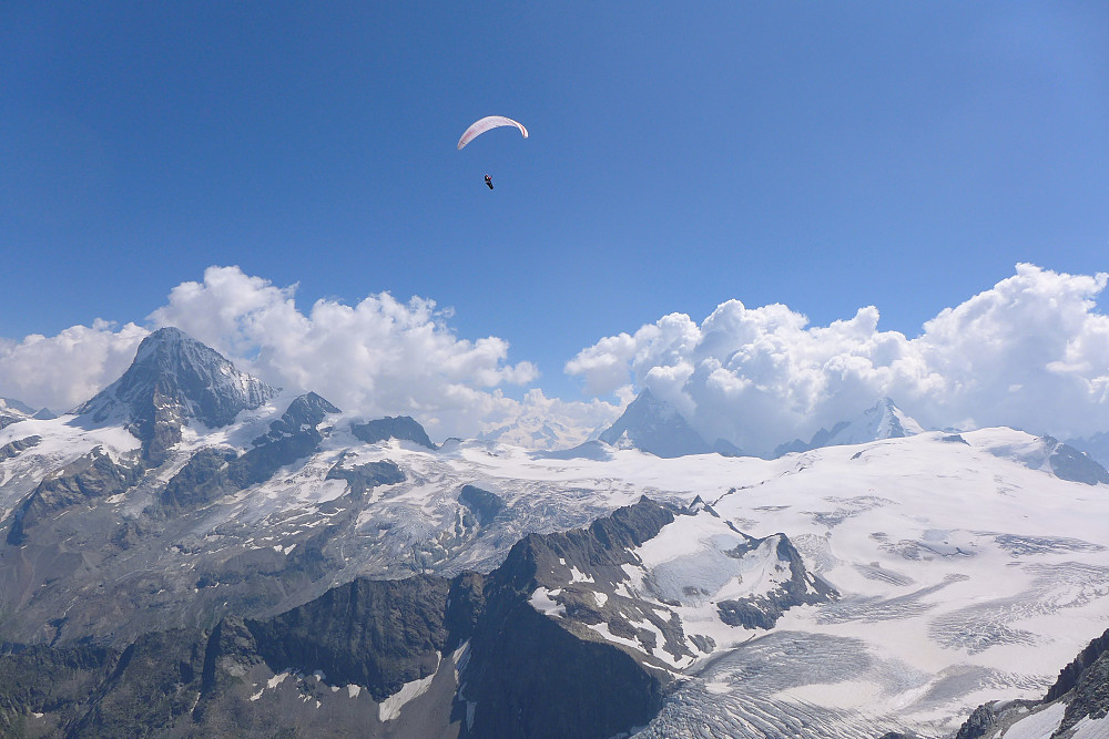 View eastwards toward Dent Blanche, Matterhorn and Dent d'Herens - with a paraglider cruising past!