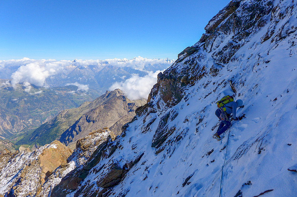 Traversing some snow-plastered slabs just below the summit of the Dirruhorn