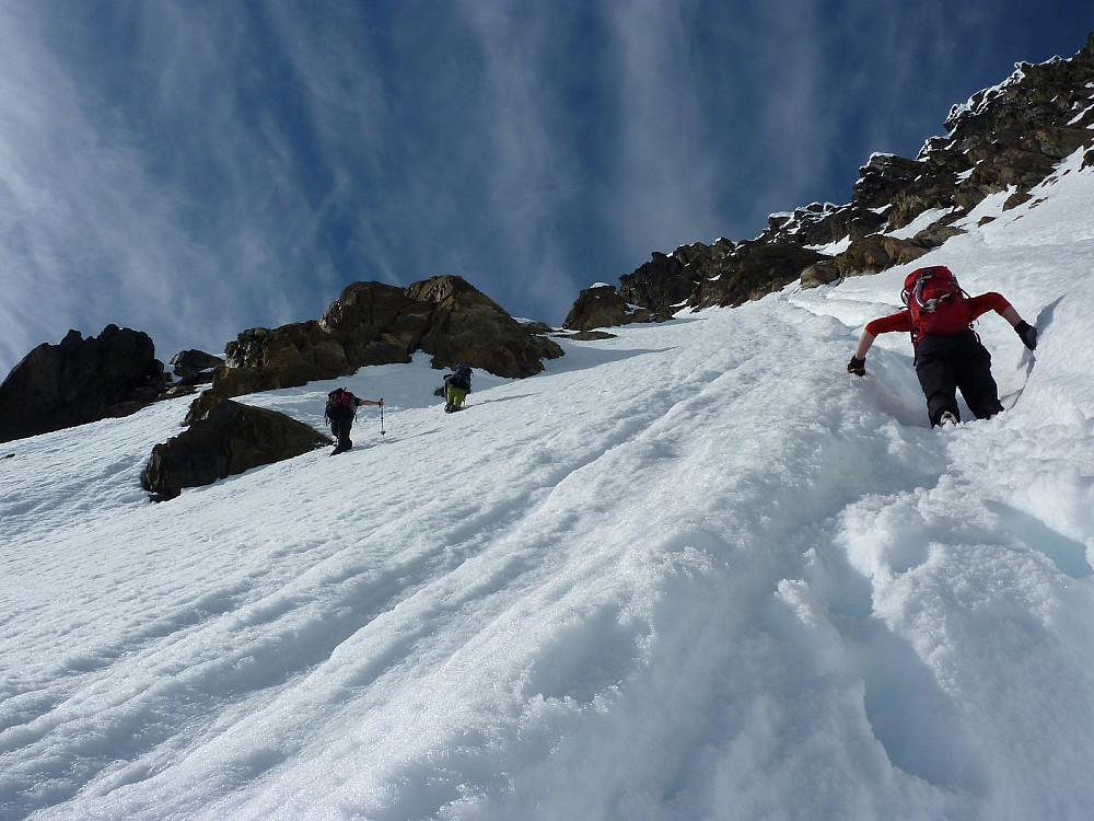 Ascending the gully on foot after swapping skis for crampons and poles for ice axes|