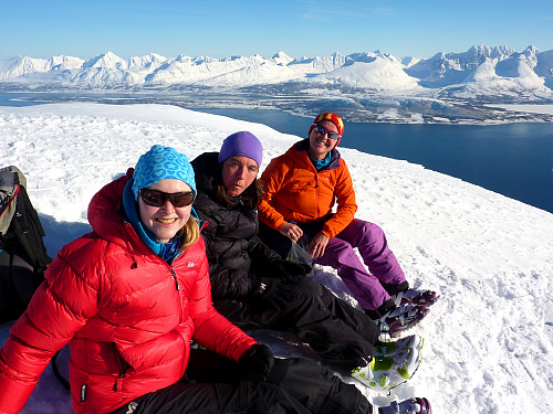 Gjengen sitter smilende på toppen. Lyngsalpene i bakgrunnen