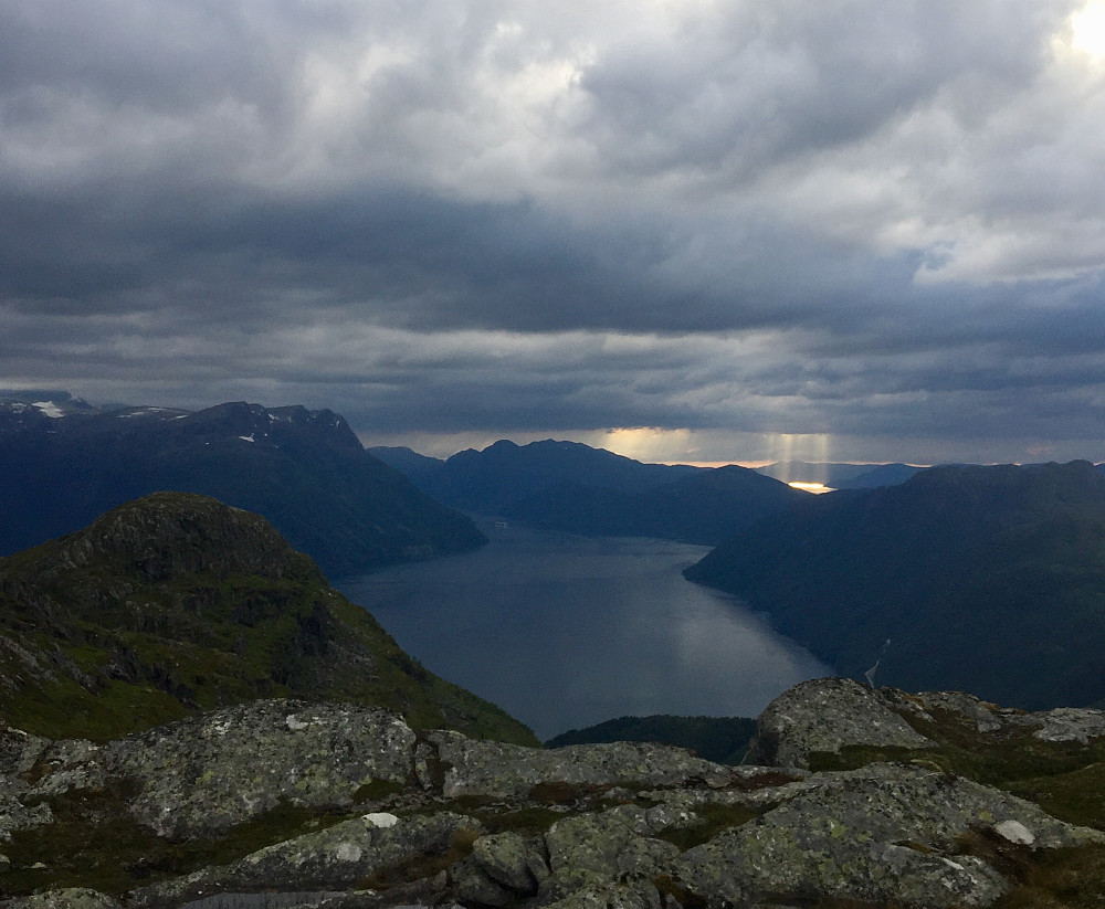 Nydelig og dramatisk lys i ytre og en cruicebåt på vei ut fjorden