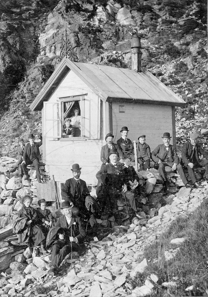Bildet er tatt av Gustav Brosing (1908-1966). Det har tittelen "Sandviksfjellet, Smedmester Pettersens hytte", viser en tidlig utgave av hytten og er hentet fra Billedsamlingen Marcus UIB ubb-bros-02582.