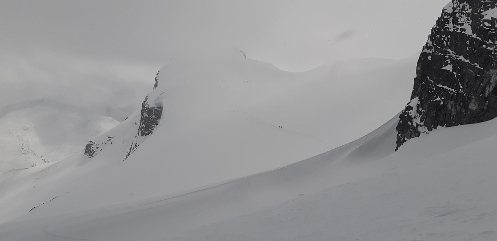 Storebjørn med snø og skyer rundt toppen. 
