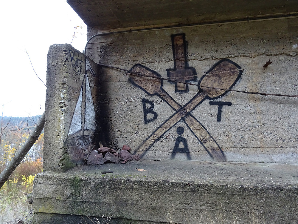 Graffiti på en svær betongkonstruksjon inne i skogen