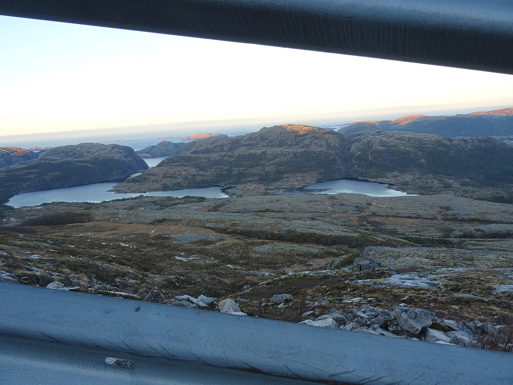 Utsikt fra det doble autovernet mot fra venstre Lindsetvatnet og Sørmelansvatnet. Pb-toppen med sol i midten heter Middagsfjellet