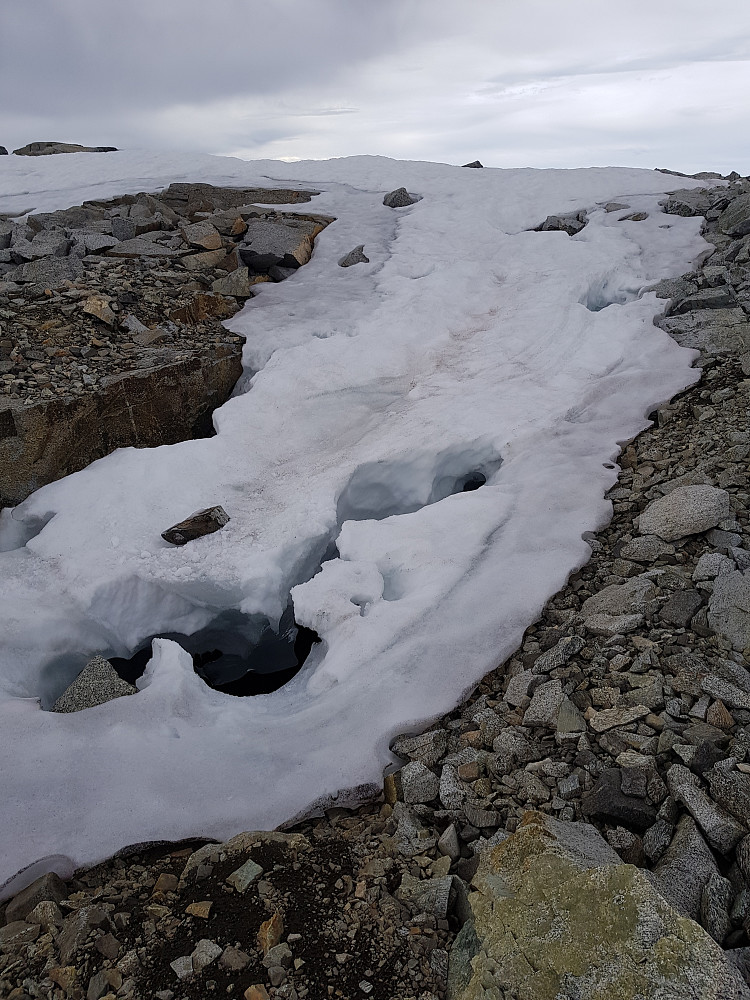 Hullet er stort. Alt som ligger av snø her i midten av bildet dekker hullet (Bortsett fra de meterne på toppen, hvor fjellet henger sammen)
Jeg kom gående fra venstre og gikk heldigvis såpass langt opp at jeg om jeg hadde gått utpå snøen/isen nok ikke hadde gått igjennom. Men heldigvis ble jeg oppmerksom på hullene i snøen og stoppet opp.